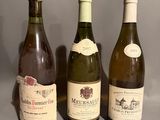 three bottles of wine are lined up on a gray surface