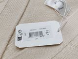 the label on a sweater is attached to a tag on a hanger