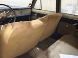 dashboard of an old car with a tan cloth on the seat