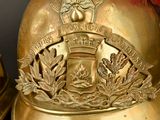 a gold helmet with a red feather on top of it