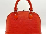 a close up of a red handbag on a white background