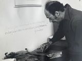 photographie en noir et blanc d'un homme travaillant sur un morceau de bois