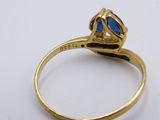a close up of a gold ring with a blue stone in it
