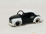 une petite voiture en noir et blanc posée sur une surface blanche