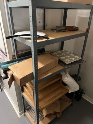 une étagère sur laquelle sont posées de nombreuses boîtes et casseroles