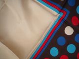 a close up of a colorful polka dot pattern on a black and white blanket