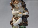 a figurine of a child sitting on a tree stump