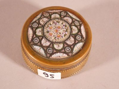 a small round box with a decorative design on it