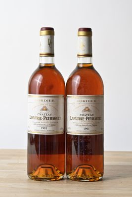 deux bouteilles de vin posées l'une à côté de l'autre sur une table en bois