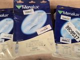 three packets of menalux toothbrushes are sitting on a table