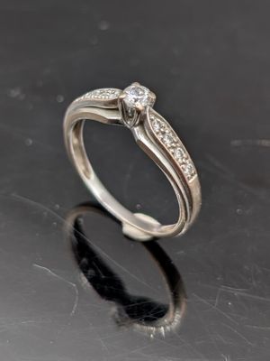 gros plan d'une bague en diamant sur une surface noire