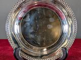 an antique silver plate on a stand on a red carpet