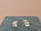 pair of square crystal stud earrings on a green marble surface
