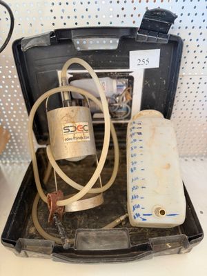 a suitcase with a hose and a bottle of water in it