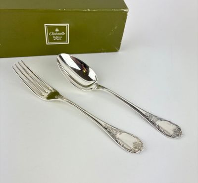 two forks and two spoons sitting next to a green box