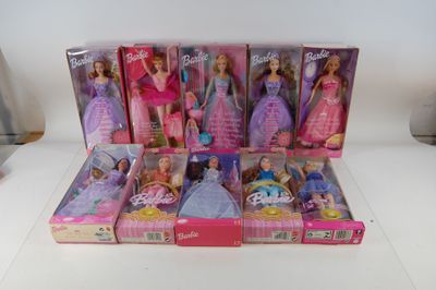 il y a beaucoup de poupées Barbie dans la boîte posée sur la table