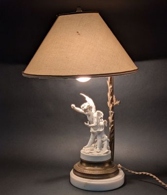 une lampe blanche ornée d'un oiseau, posée sur une table