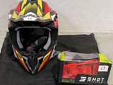 un casque posé par terre à côté d'un sac