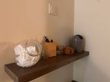a wooden shelf with a glass jar on top of it