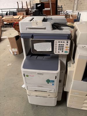 un tas d'imprimantes et d'autres équipements électroniques dans un entrepôt