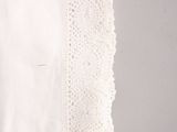 lace trimming on a white handkerchief on a gray background