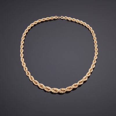 un collier en or avec un motif de corde torsadée sur fond noir