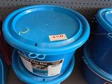 Plusieurs seaux bleus sont posés sur une étagère dans un magasin.
