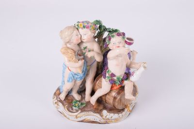 une figurine représentant trois enfants assis sur un rocher