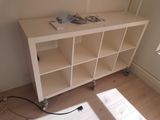 a white book shelf with books on it in a room
