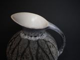 a black and white vase with a spoon in it