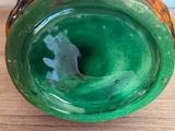 a close up of a green vase on a wooden table