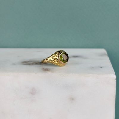 a close up of a gold ring with a green tourmaline stone