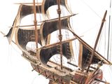 a wooden model of a sailboat on a white surface