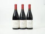 trois bouteilles de vin rouge posées sur une table blanche