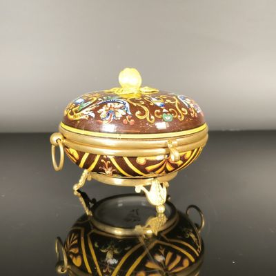 une petite boîte décorative posée sur une surface noire