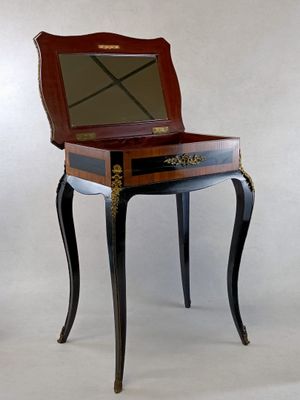a small wooden table with a mirror on top of it