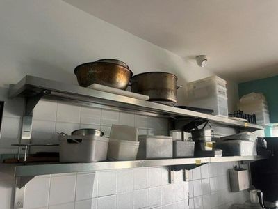 many pots and pans on the shelves in the kitchen