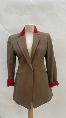 beige and red jacket on a mannequin stand on a white background