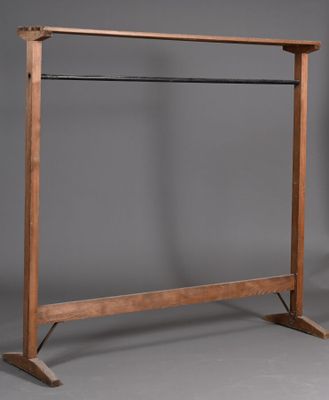une image représentant un portant à vêtements en bois sur fond gris