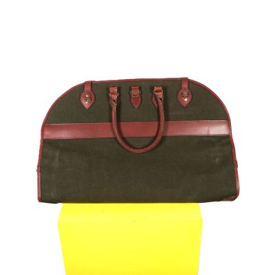 un gros plan d'un sac à main marron et jaune posé sur un poteau jaune
