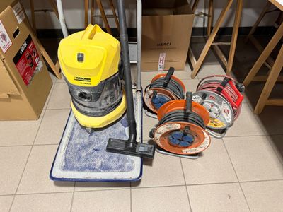 un aspirateur posé sur le sol à côté d'autres objets