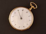 a gold pocket watch with roman numerals on it