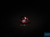 un diamant rouge sur une surface noire