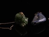 trois anneaux en pierre de couleurs différentes sur une surface noire