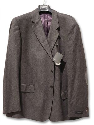 the suit jacket is hanging on a hanger on a white wall