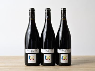trois bouteilles de vin posées sur une table en bois