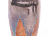 a black vase with orange and blue designs on it
