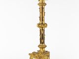 a gold plated candle holder with a bird on top