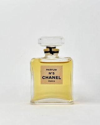 a bottle of perfume sitting on top of a white surface