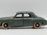 an old model of a green car on a white surface